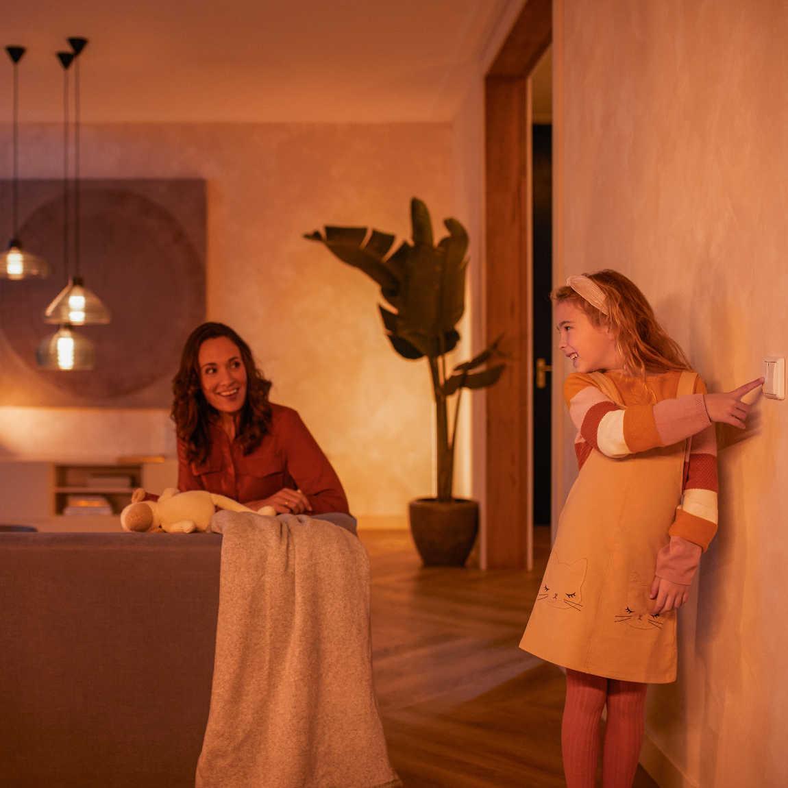 Philips Hue Wandschalter Modul Doppelpack - Lifestyle Kind am Lichtschalter mit Mutter