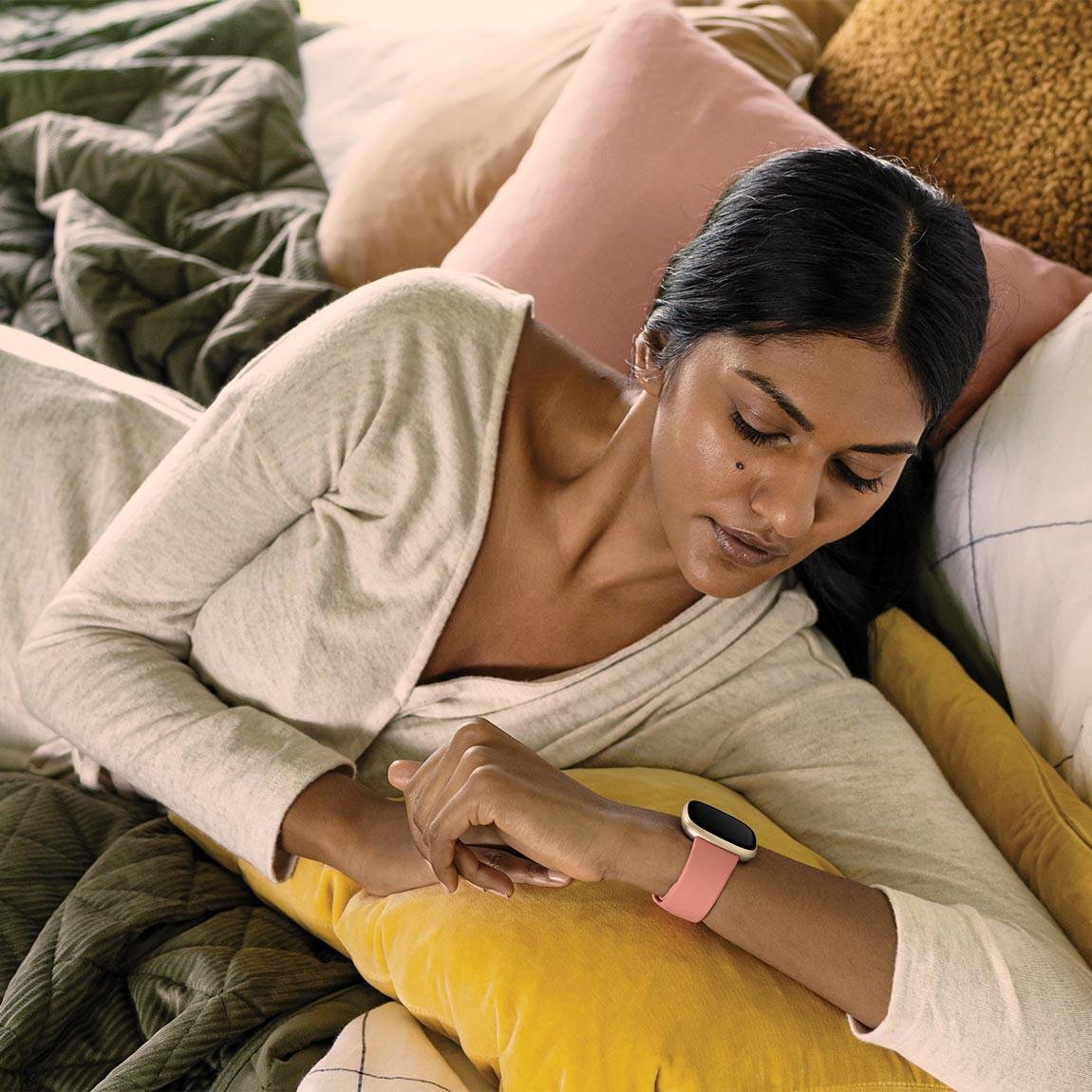 Fitbit Versa 3 - Smartwatch mit Sprachassistent - altrosa auf dem Bett