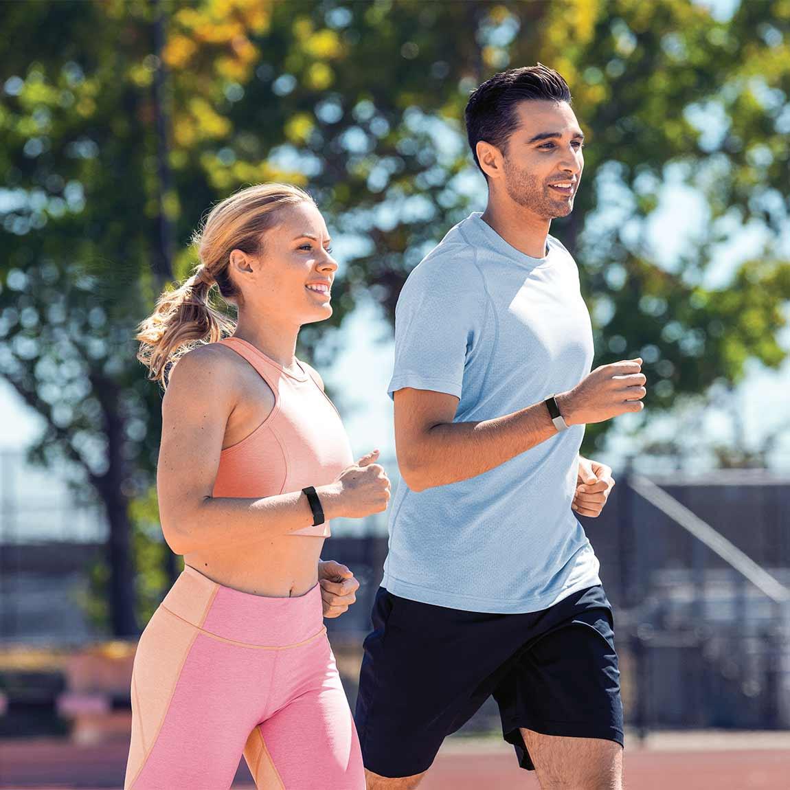 Fitbit Inspire 2 - Gesundheits- und Fitness-Tracker - schwarz und mondweiß Paar beim Joggen