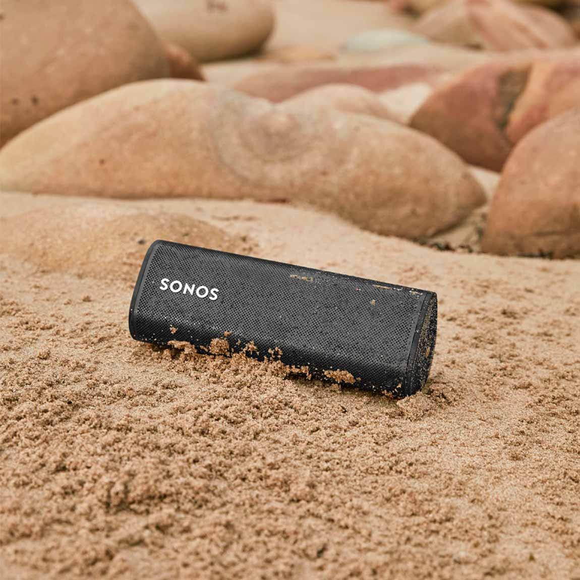Sonos Roam - mobiler wasserdichter Smart Speaker am Strand im feuchten Sand